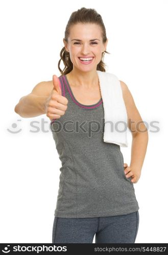 Smiling fitness young woman showing thumbs up