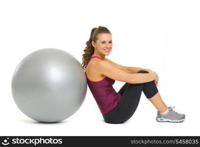 Smiling fitness young woman sitting near fitness ball