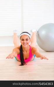 Smiling flexible young girl making gymnastics exercise at living room&#xA;