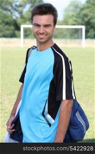 Smiling footballer with kitbag
