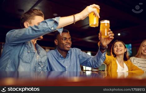 Smiling friends drinks beer at the counter in bar. Group of people relax in pub, night lifestyle, friendship, event celebration. Smiling friends drinks beer at the counter in bar