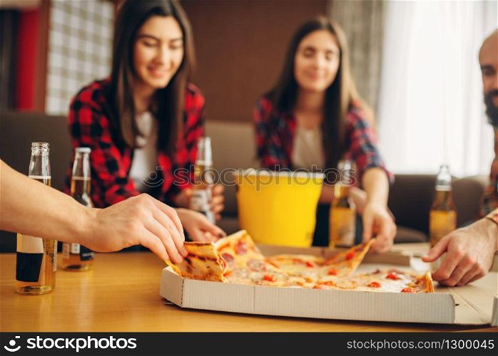 Smiling friends drinks beer with pizza at the house party. Good friendship, group of people leisures together. Cheerful company celebrate the event. Friends drinks beer with pizza at the house party