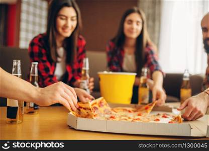 Smiling friends drinks beer with pizza at the house party. Good friendship, group of people leisures together. Cheerful company celebrate the event. Friends drinks beer with pizza at the house party