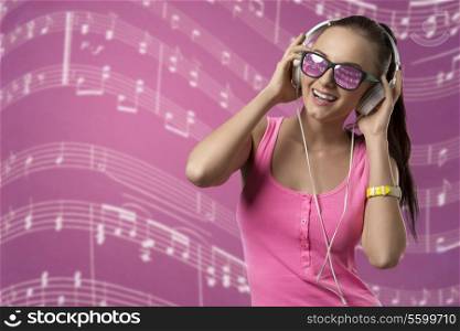 smiling funny girl listening music with headphones and posing with pink singlet and long brown ponytail