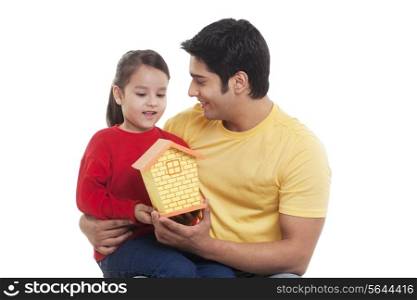 Smiling girl and man holding dollhouse