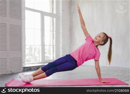 smiling girl doing stretching exercise gym