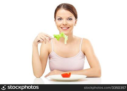 Smiling girl eats the leaf of salad isolated