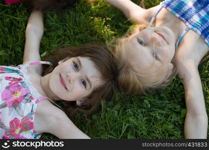 Smiling girl friend lying on the grass