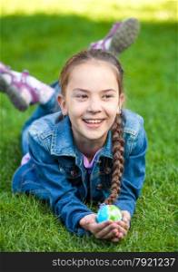 Smiling girl having fun on grass and holding globe