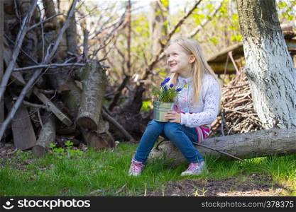 smiling girl holding flowers hyacinths in a pot