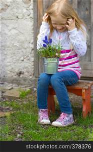 smiling girl holding flowers hyacinths in a pot
