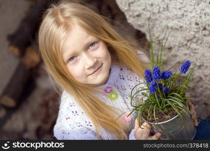 smiling girl holding flowers hyacinths in a pot