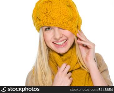 Smiling girl in autumn clothes pulling hat over head