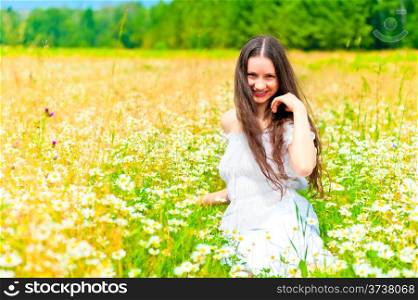 smiling girl in camomile field rests