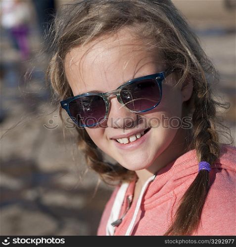 Smiling girl in sunglasses and braids