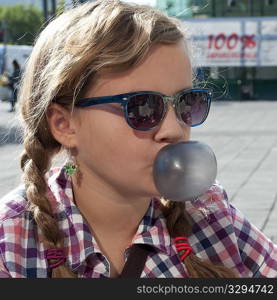 Smiling girl in sunglasses and casual chequered shirt