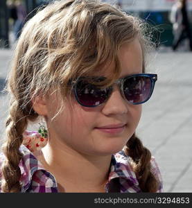 Smiling girl in sunglasses and casual chequered shirt