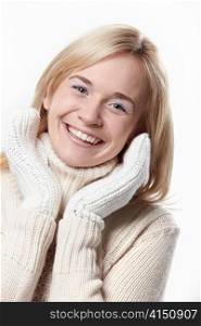 Smiling girl in the mittens on a white background