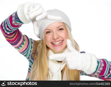 Smiling girl in winter clothes framing with hands