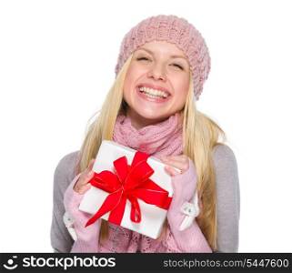 Smiling girl in winter clothes holding present box