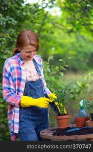 smiling girl plants a flowers in the garden. flower pots and plants for transplanting