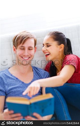 Smiling girl showing something her boyfriend by pointing in book &#xA;