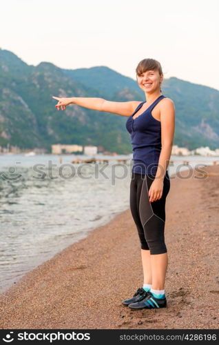 smiling girl showing something in the sea