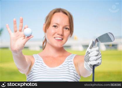 Smiling girl shows a camera in the ball and a golf club on a white background