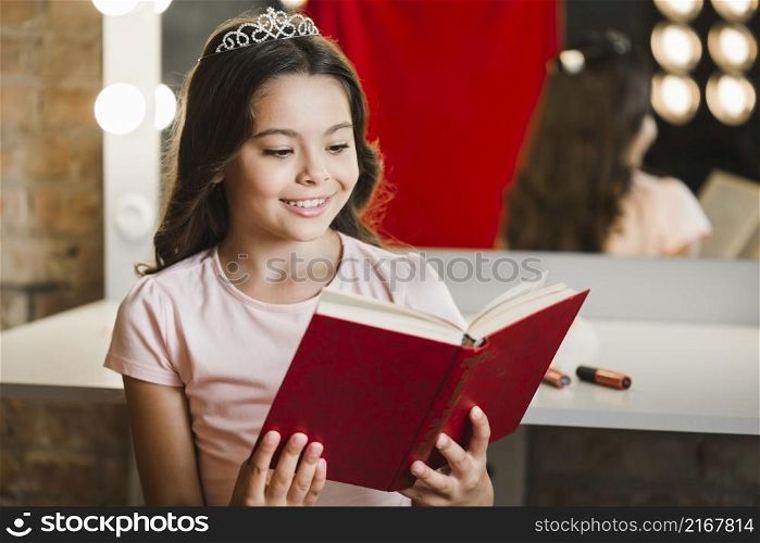 smiling girl sitting makeup room reading book