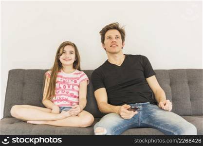smiling girl sitting sofa with her father