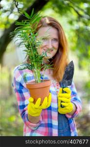 smiling girl transplants flowers in the garden. flower pots and plants for transplanting