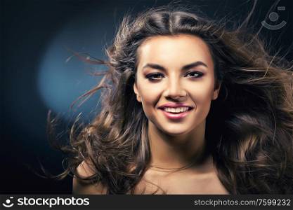 smiling girl with long hair on wind