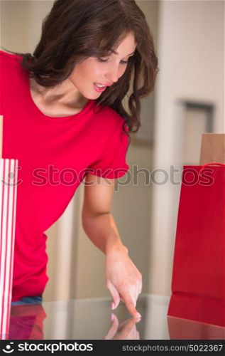 Smiling girl with shopping bags at store pointing at showcase