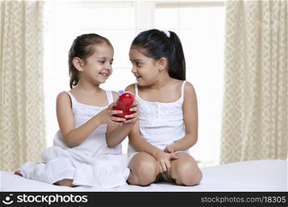Smiling girls playing with a toy