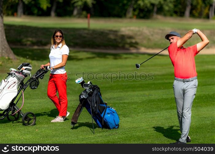 Smiling golfing couple enjoying a game of golf