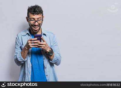 Smiling handsome boy texting with his cell phone isolated, young latin man happy with his cell phone isolated, happy teenager texting with his cell phone