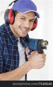 smiling handyman holding drill in his hand
