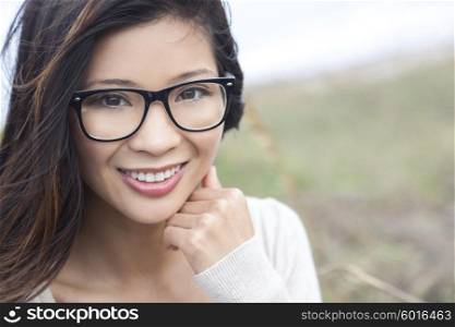 Smiling happy beautiful young Asian Chinese woman or girl wearing geek glasses outside