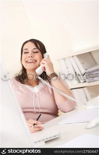 Smiling happy business woman talking on the phone at office