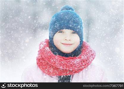 smiling happy child in winter / healthy cheerful girl in warm clothes at a frosty winter walk. Snow portrait of a child. Concept of health, happiness, family