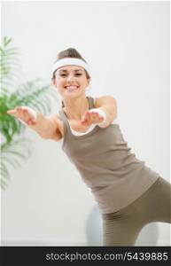 Smiling healthy woman making gymnastics exercise