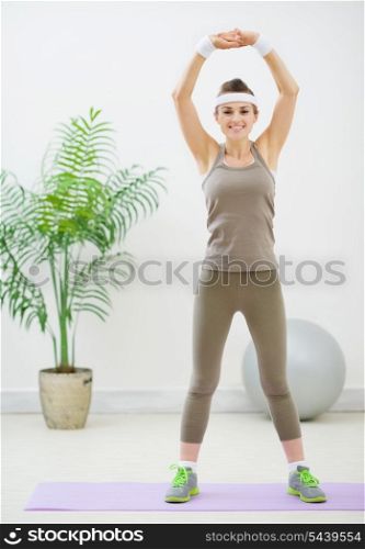 Smiling healthy woman making stretching exercises