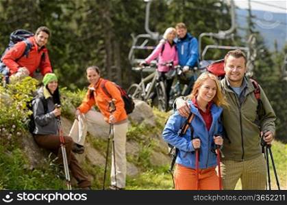 Smiling hikers and cyclists posing peak of the mountain