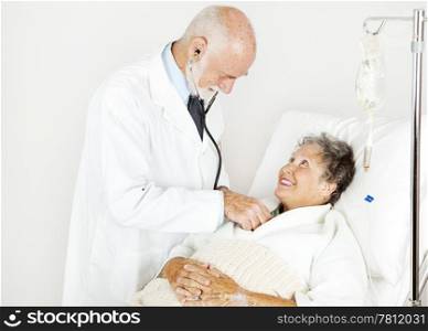 Smiling hospital patient gets examined by handsome doctor.