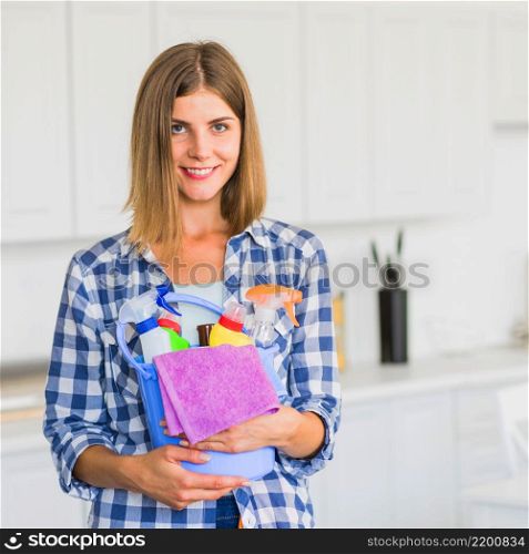smiling housewife holding cleaning equipment hands