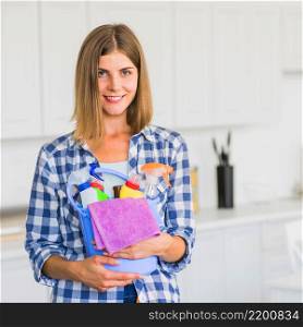 smiling housewife holding cleaning equipment hands