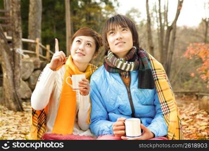 Smiling Japanese teenage couple drinking tea