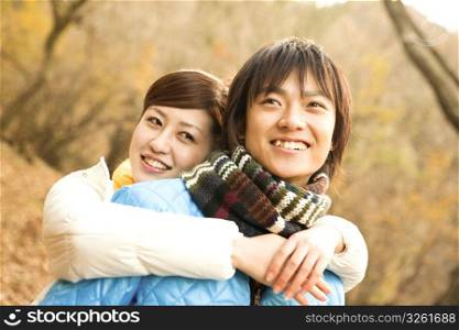 Smiling Japanese teenage couple in the woods