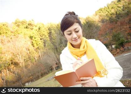Smiling Japanese teenage girl reading a book