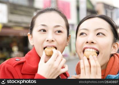Smiling Japanese teenage girls eating